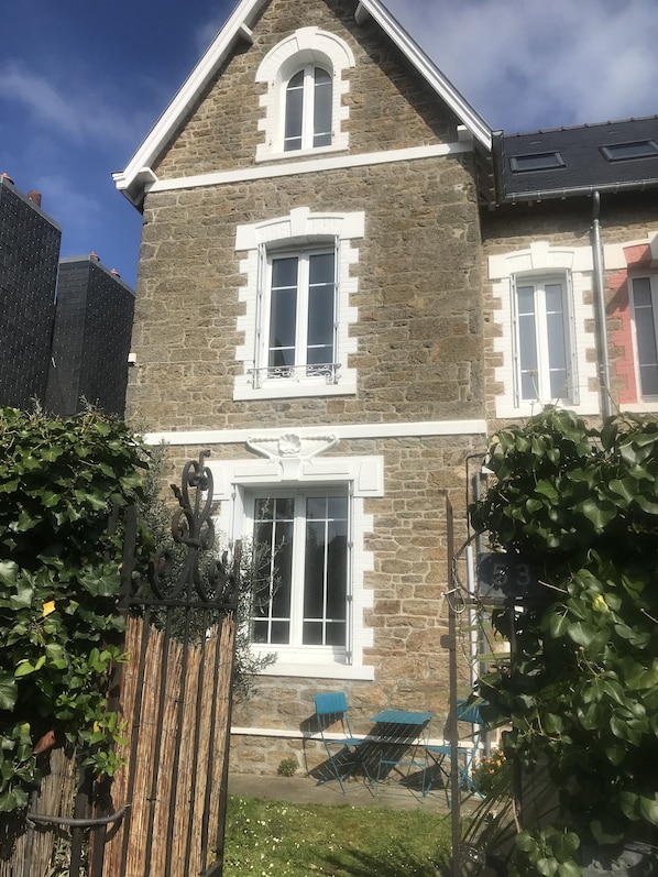 Facade avant la maison avec petit jardin au sud
