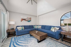 Spacious living room featuring sectional, marble fireplace, smart TV, and stunning ocean views