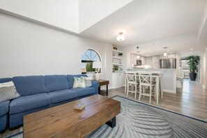 Spacious living room featuring sectional, marble fireplace, smart TV, and stunning ocean views