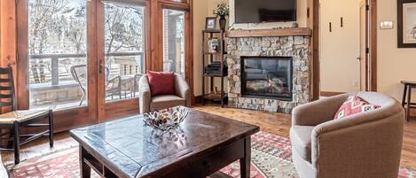 Comfortable living room, with fire place and TV and steps right off to the patio.