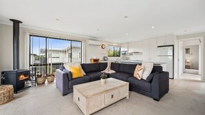 Relaxing lounge area with L-shaped sofa and wood burning fire 