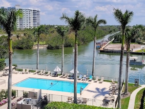 Pool with plenty of tables, chairs and loungers on the bay