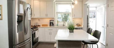 Bright kitchen with back door leading to lovely garden patio with hammock and chairs for lounging and al fresco dining. Washer and dryer in closet on right, 1/2 bath on right also. Welcome basket of goodies!