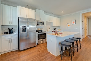 Bright open kitchen stocked with your basic cooking essentials. Complete with stainless steel appliances and breakfast bar seating. -Unit 1-
