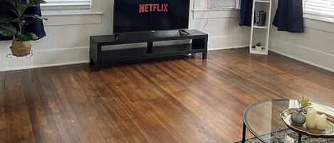 Spacious living room with hardwood floors. 55" inch TV with Netflix, Hulu + more