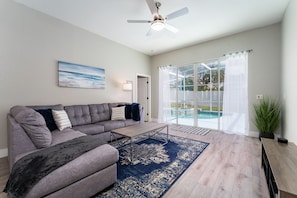 Spacious Living Room Area with Comfy Seating and Access to Pool Deck