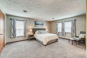 Primary bedroom w queen-sized bed and smart tv