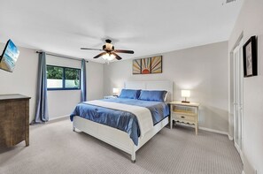 Spacious master bedroom with a king bed, a TV, and en suite master bathroom with a walk in shower. (1)