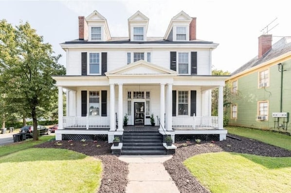 Stunning historic Victorian with beautiful front porch and rocking chairs.
