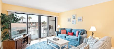 This sun-filled living room opens to the balcony and brings in all the beachy vibes with cozy seating and natural light.