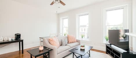 Living room with 55" smart TV has tons of natural light with oversized windows