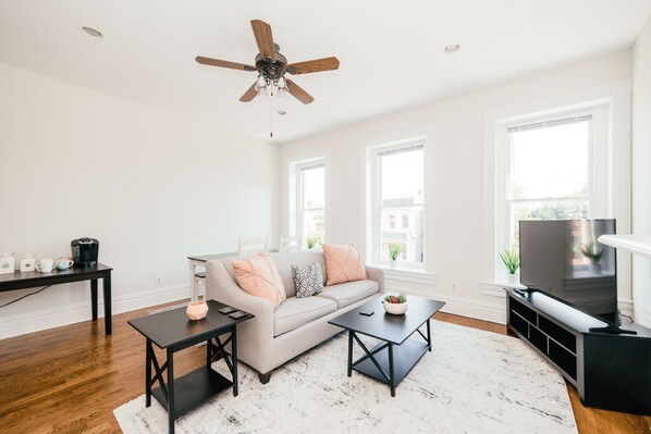 Living room with 55" smart TV has tons of natural light with oversized windows