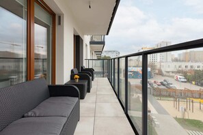 A balcony with stylish seating and a view of the surrounding residential area.
