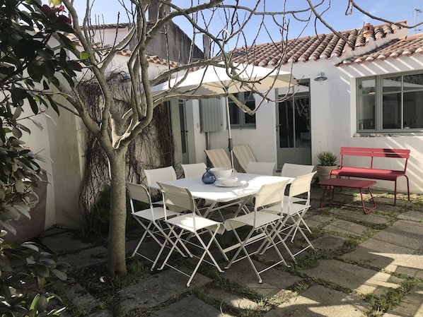 Une jolie cour arborée pour les repas sous le figuier. 