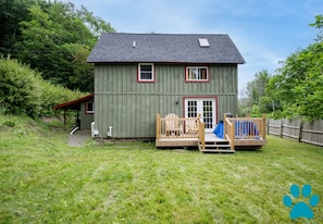 Side deck looks out onto spacious side yard. Fence along front of the property gives privacy from the road.