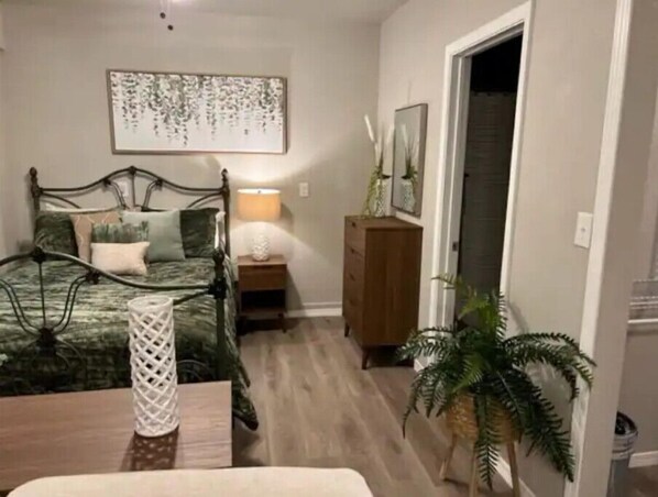 Bedroom area Queen bed with dress and chest. Door leads to full bathroom. 