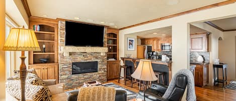 Living Room with plush couch, 2 electric, leather recliners, gas fireplace, and smart TV