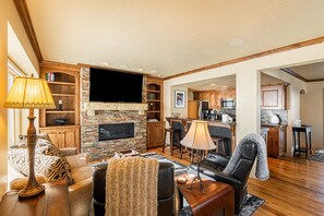 Living Room with plush couch, 2 electric, leather recliners, gas fireplace, and smart TV