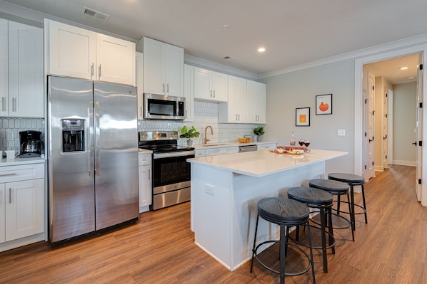 Unit 1: Fully Equipped Kitchen stocked with basic cooking essentials and stainless-steel appliances.
