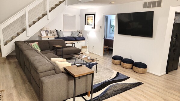 Family Room with massive 8+ person sectional, 2 reclining chairs on end.
65" Smart TV, Open concept for families..