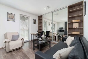 A cozy seating area with armchairs, a sofa, and large windows allowing natural light.
