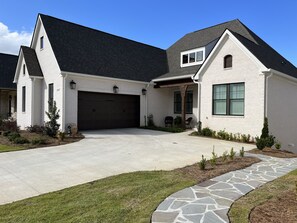 Stone walkway leads to backyard that boasts a gorgeous view of the golf course