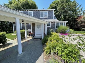 Side entrance to home with gas grill in back yard