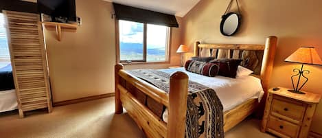 The beautiful Master Bedroom with a full ensuite bathroom, an extra double bed with a privacy screen, cable TV and magnificent views across the Rockies.