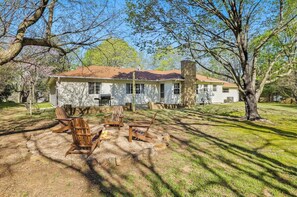 In our large backyard, you'll see a fire pit surrounded by four adirondack chairs.