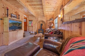 Nicely appointed living room / dining area / kitchen with leather furniture, gas stove & large flatscreen SmartTV.