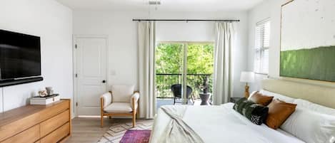Master upstairs bedroom w/ en suite bathroom & a balcony overlooking park trees 