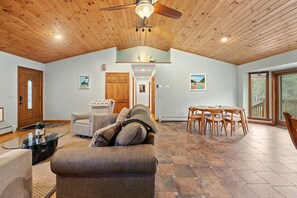 Open-concept kitchen, living, and dining space with high ceilings.