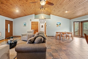 Open-concept kitchen, living, and dining space with high ceilings.