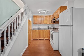 🍽️ Our modern kitchen is stocked with all the essentials for a stress-free cooking experience, plus plenty of counter space for food prep and dining. And just off to the side, you'll find the conveniently located staircase leading up to the other floors of our cozy home.