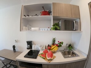 Functional kitchen with a microwave oven and a sink - cook and dine with convenience in Playa del Carmen.