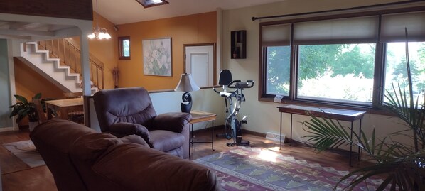 Bright and open living room to sunken dining room with stairway to loft