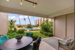 Large shaded lanai with dining table for 4 people and 2 sitting chairs. 