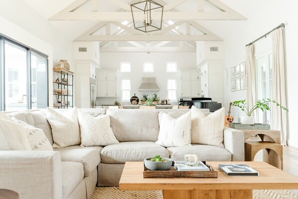 Grand room with vaulted ceilings and wood trusses.  Dining, living & kitchen 
