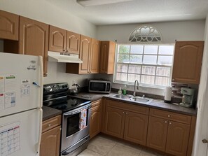 Full kitchen with full size refrigerator. 