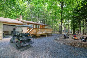 Large front yard with game room garage, golf cart available for rent, & fire pit