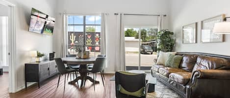 Bright living room with sofa, smart tv, and dining table