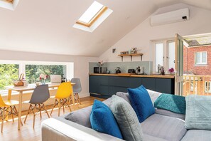 Main living area taken from the television showing dining table and corner sofa