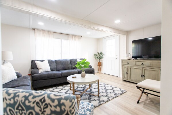 Spacious living room with lots of seating and 55” television