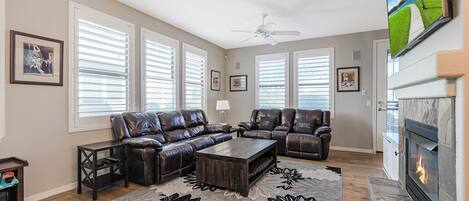 Living room with 4 built-in recliners, fireplace and a smart TV.