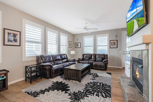 Living room with 4 built-in recliners, fireplace and a smart TV.