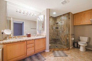 Master bathroom with dual vanities, large tub, walk-in shower and toilet.