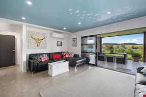 Living area walk out to outdoor dining. Wall of windows open to enjoy the view.