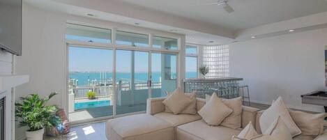 First floor living space that looks out at the pool and bay