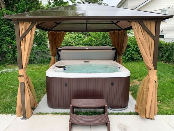 Luxury meets tranquility: Relax and rejuvenate in our outdoor hot tub, surrounded by the serene beauty of our property.