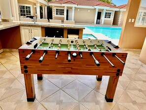 Foosball table for playing near swimming pool.